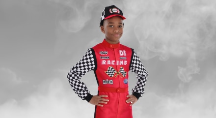 Un enfant portant un costume de pilote de voiture de course.