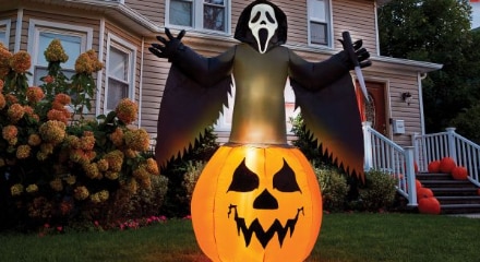 Le personnage Ghostface de Frissons sortant d’une citrouille d’Halloween gonflable décorative.