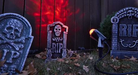 Three tombstone decorations with lights glowing.