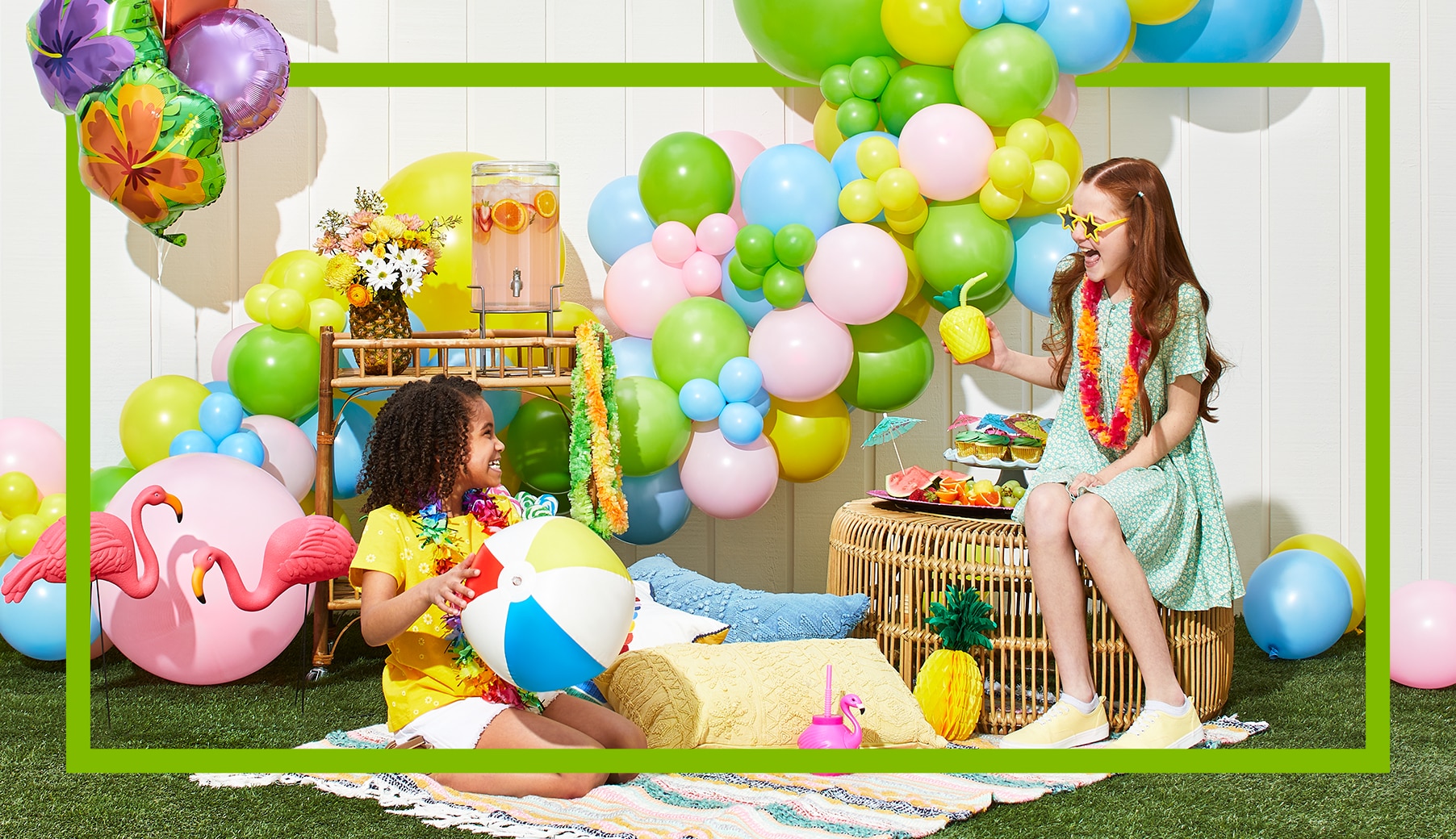 Two girls looking at each other in front of a bouquet of mermaid-themed balloons and a large number 6 balloon.