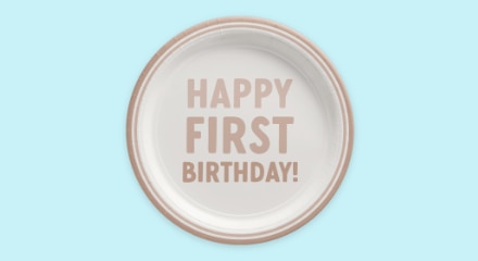 Une assiette sur laquelle on peut lire « HAPPY FIRST BIRTHDAY ».