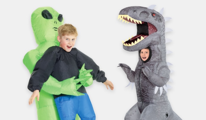 A boy wearing an inflatable alien holding a person costume and a girl wearing an inflatable dinosaur costume.