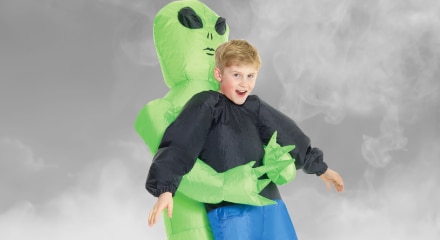 An inflatable alien holding a person costume.