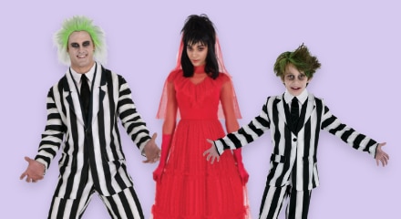 A man and a boy wearing Beetlejuice costumes and a woman wearing a Lydia costume.