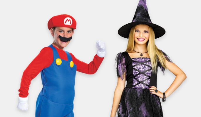 A boy wearig a Super Mario Bros. Mario costume standing beside a girl wearing a witch costume.