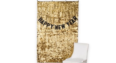 A gold tinsel wall hanging decoration with the words 'Happy New Year'.