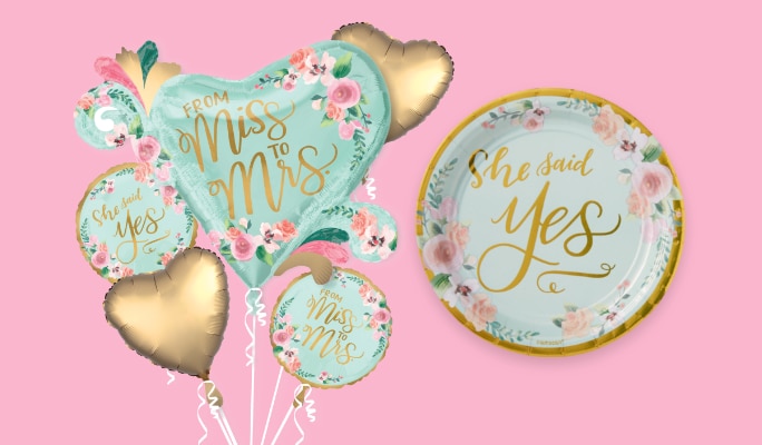 A bouquet of balloons that read 'From miss to mrs.' and a plate that reads 'She said yes'.