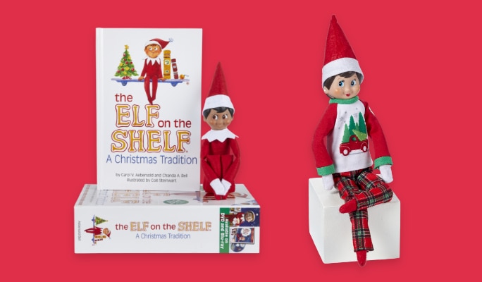 Un livre Elf on the Shelf à côté de deux figurines Elf on the Shelf enfant.