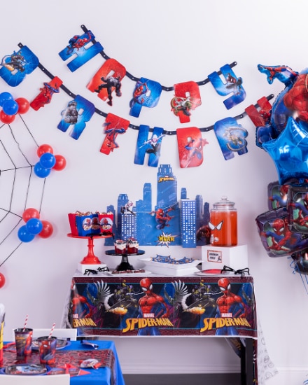 A room decorated with various Spider-Man-themed decorations, balloons and tableware.