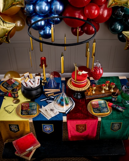 A room decorated with various Harry Potter-themed decorations, balloons and tableware.