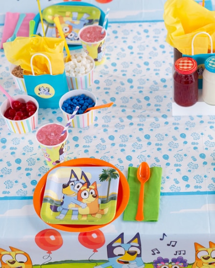 Une table préparée pour une fête sur le thème de Bluey.