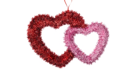 A large red heart and smaller pink heart tinsel wall decoration.