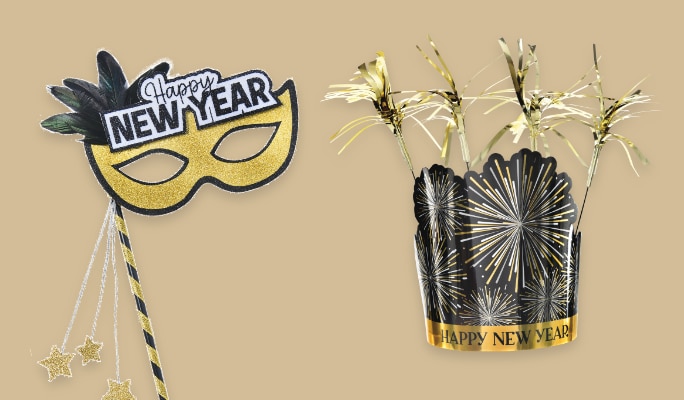 A black, gold and silver masquerade party mask that says 'Happy New Year' beside a firework party crown with gold tinsel.