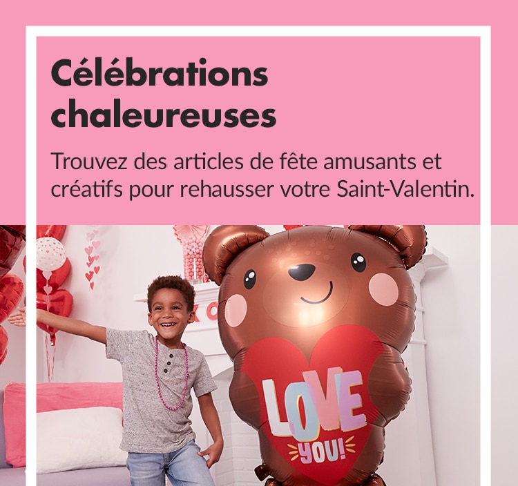 Grand ballon en aluminium en forme d’ourson en peluche tenant un cœur devant des décorations de la Saint-Valentin variées.