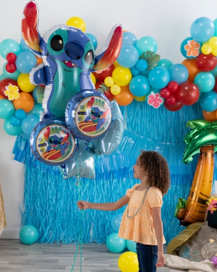 Blue tinsel backdrop with Stitch balloon bouquet.