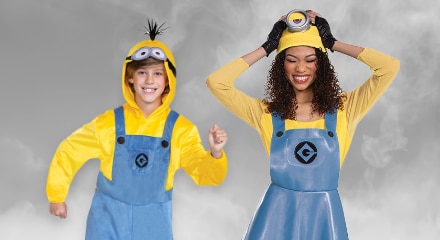 Two people dressed in Minion costumes with yellow shirts, blue overalls, and black gloves.