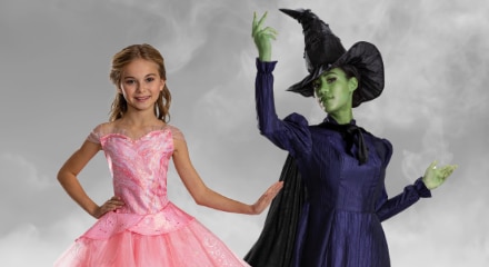 Two people in Wicked costumes: Elphaba and Glinda.