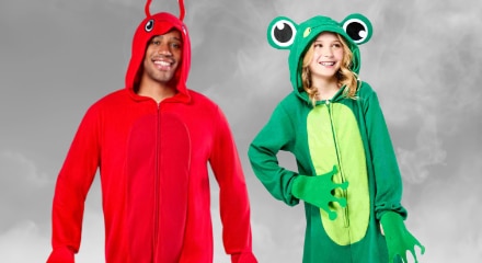 Two people in animal onesies: a red lobster and a green frog.