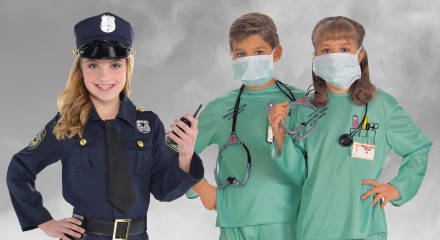 Three people in costumes: a police officer and two healthcare workers in green scrubs.
