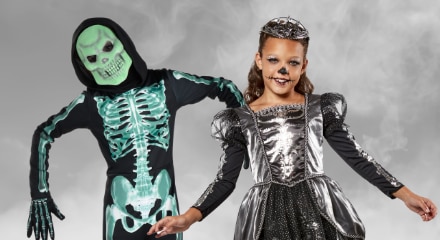 Two children in skeleton Halloween costumes.