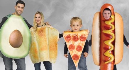 Four people dressed in food costumes: an avocado, a slice of toast, a pizza slice, and a hot dog.