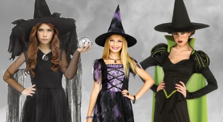 Three people dressed in witch costumes.