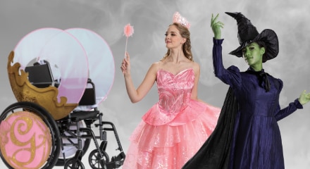 Two people in Wicked costumes: Glinda, Elphaba and a wheelchair decorated as a carriage.