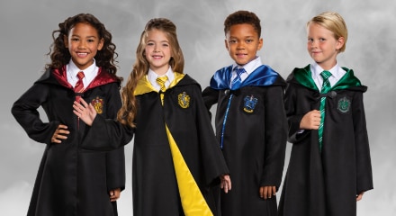 Four children dressed in Harry Potter house robes: Gryffindor, Hufflepuff, Ravenclaw, and Slytherin.