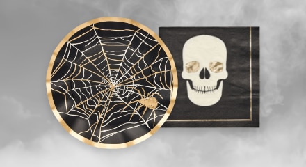 Paper plate featuring a spiderweb pattern and skull-themed napkins.