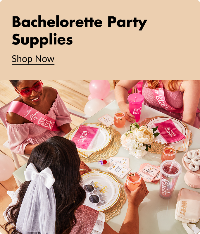 Three women sitting at a table decorated with pink and white plates, party favours, drinks and snacks. 