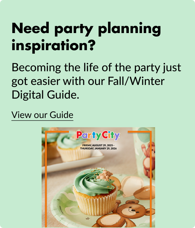 A cupcake with green icing sitting on a white and green party plate with a cartoon bear.