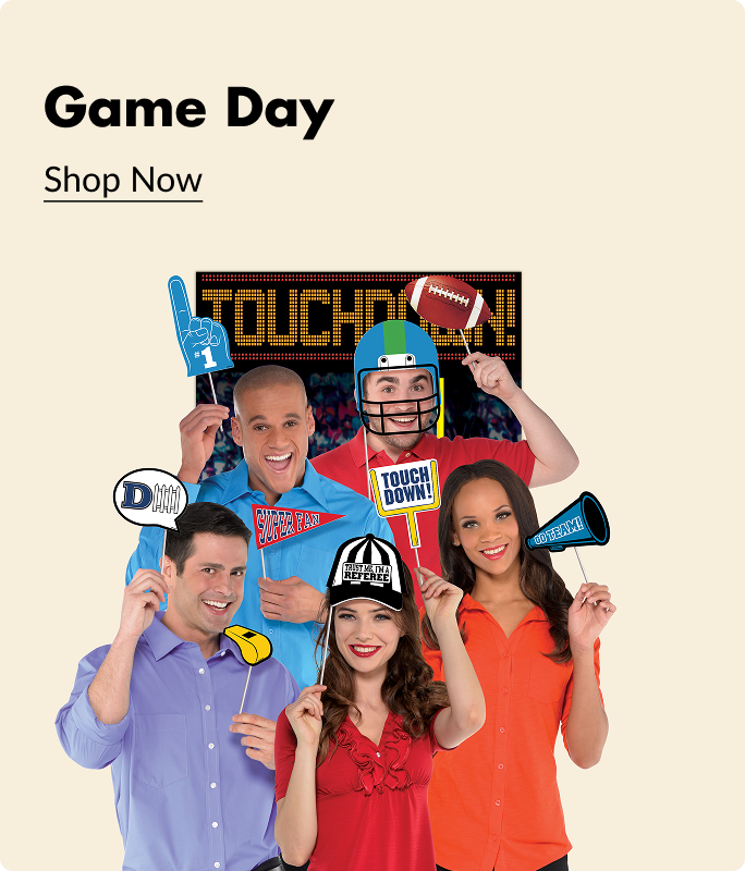 A group of adults holding up game day themed signs and party favours in front of a backdrop that says 'Touchdown'.