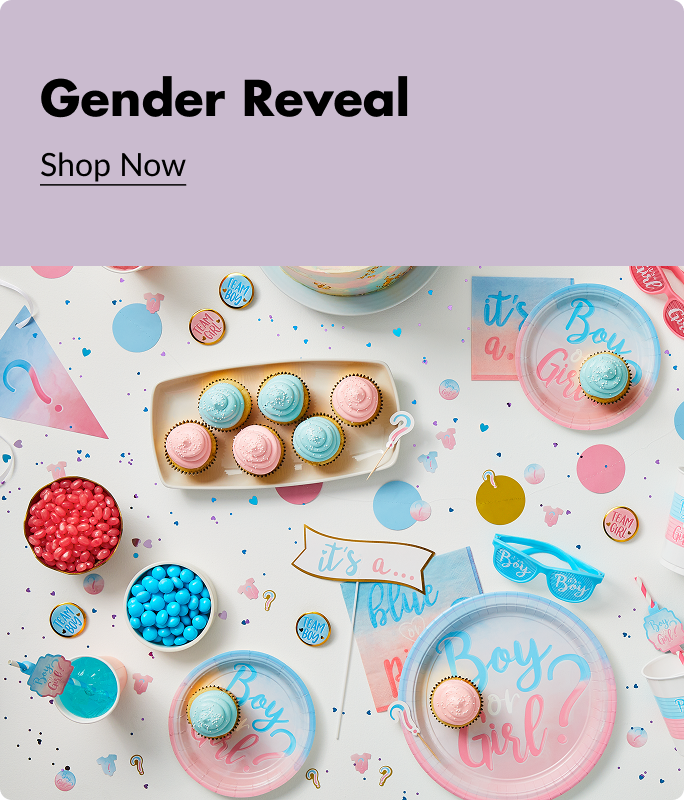 An overhead show of pink and blue cupcakes, candy, party favours and party playes that say 'Boy or Girl'.