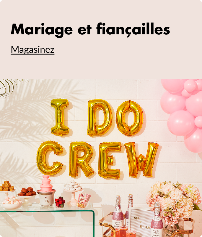 Ballons en forme de lettres dorées qui épellent « I Do Crew » posés contre un mur à côté d'un bouquet de ballons roses et au-dessus d'une table décorée avec des collations, des boissons et des fleurs.
