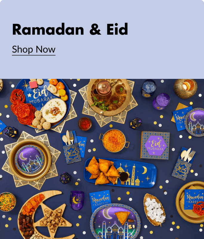 A Ramadan and Eid themed table spread decorated with gold blue and purple accents, tableware, serveware and various food.