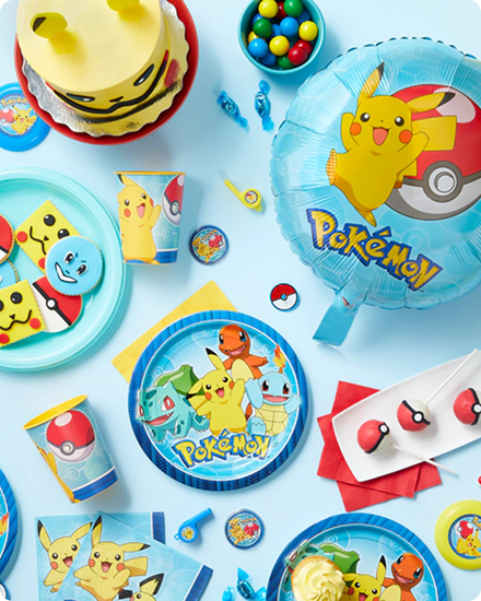Une table décorée de décorations, de vaisselle et de plats de service à thème de Pokémon. 